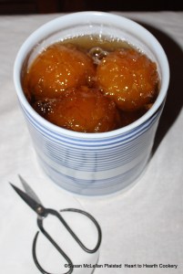 After the Seville oranges cut to look like artichoke leaves have been boiled until they look clear in syrup for the receipt (recipe) "To preserve Oranges Whole" put them into pots and pour the syrup upon them. When they are cold put papers dipped in the best brandy over them. The cut white paper ready for the brandy is under the scissors