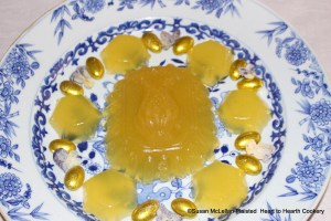 This is the presentation of the receipt (recipe) "To make Orange Jelly" from the pineapple and patty pan molds.  This presentation of the jelly made from the grated rinds of 2 China oranges, 2 lemons and 2 Seville oranges infused in Seville orange juice and jelled with isinglass is garnished with almond comfits gilded with gold leaf.