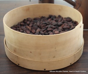 Pictured is a large measure containing dried fermented cacao beans from the first of my two day process of preparing the receipt " To make Chocolate with Water". There is no aroma of chocolate from these beans.