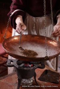 After the anise seeds have been warmed on the comfit pan for the receipt (recipe) Anise Comfits, a small ladle of hot sugar syrup (a charge) is added to the center well of the seeds and then with the flat of a hand the seeds with the syrup are moved around the comfit pan (while swinging the pan over the heat) until the seeds are dry.  This is the first charge.