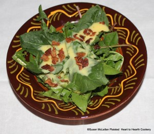 After the sauce (prepared from whisked eggs, water, sugar and vinegar) is ladled on the fresh dandelions then the crisp schpeck (bacon) is crumbled on for the Pennsylvania German receipt (recipe) Heesse Schpecksass (Hot Bacon Sauce).