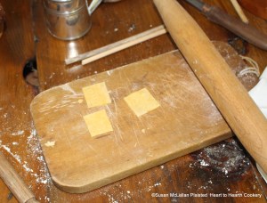 After the eggs have been mixed well with the flour for the receipt (recipe) Maccaroni, knead the dough for quite awhile until it is pliable and ready to roll.  As pictured, I rolled a small amount of the dough at a time using a minimal amount of additional flour and cut small squares.  The two small dowels will be used to roll the macaroni.