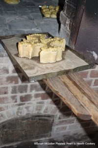 After the lid for the receipt (recipe) A Hen Pye was placed, decorated and the coffin closed, the pye was ready for the oven. Pictured is the pye on the tin baking sheet being positioned in the bake oven with a peel.
