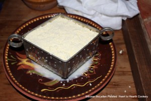 After the delicate curd has been separated from most of the whey through a linen cloth for the Pennsylvania German receipt (recipe) Egg Chees (Oya Kase), the curd is layered into the mold and allowed to continue to drain any remaining whey overnight.
