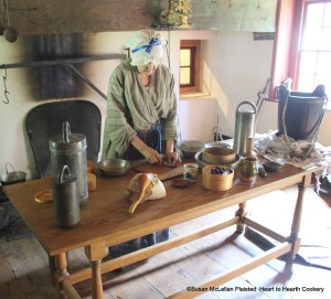 My table is ready for the receipt (recipe) To make Gooseberry Cream Ice which would be referred to as gooseberry ice cream today.  From left to right on the table are two original sabotieres, a bag of salt and gourd spoon, a sieve with a few very ripe gooseberries remaining from my preserving fresh picked ripe gooseberries a month prior, a gally pot of preserved gooseberries to be used in the ice cream which were strained through the sieve, a second sieve in a pewter basin, a wood masher, my reproduction pewter sabotiere and coopered bucket ready for the ice and salt.