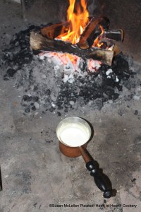 After the butter has been rubbed into the flour so that none can be seen for the receipt (recipe) To make Wigs take a pint or more of milk and make it very warm.  The milk is being heated at the hearth in an everted rim saucepan.