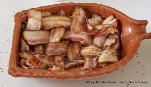 After the bacon has been neatly laid in the bottom of the rutcher and the collops seasoned with bread crumbs and parsley for the receipt (recipe) Veal Collops another way, bacon is laid neatly over and under and now the rutcher (baking dish) is ready for the oven.