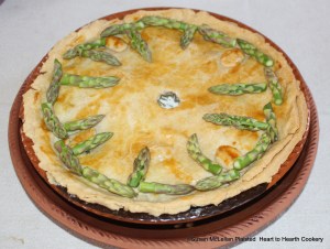 After the receipt (recipe) An Asparagus-pan-pie is baked, cream is added and the Tops reserved for garnishing arranged on the pie.  The pie is now ready for table.