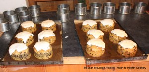 After the individual, small cakes had their cake hoops removed and before they completely cooled, an icing (made from egg white whisked stiff, fine double-refined sugar and rose water) was applied for the receipt (recipe) A Pretty Cake. The tin baking pans are then placed back into a cooler bake oven for a very short time for the icing to set. The icing needs to be more white than attain much brown color.