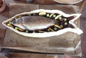 After the carp is laid into the pye for the receipt (recipe) To Bake a Carp otherways to be heaten hot, then lay on the slic't dates in halves, slic't lemon, grapes, raisins of the sun.  Large mace (not pictured) is laid on the carp prior to closing the coffin.