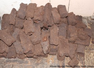 Peat is formed by the partial decomposition of plants in the wet, acidic conditions of bogs.  Peats were the main form of cooking fuels historically in the Highlands of Scotland.  The process of cutting, drying, and leading peats to the homes in peat barrels was a multi-family process.  The men cut the oblong peat cubes and women and children carefully spread the very soft, newly cut peats to dry.  This picture is the peats used for cooking bannocks.