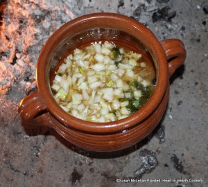 To the gravy, sweet Marjoram, and Capers, the next ingredient for the receipt (recipe) To harsh a Roast of Mutton is Onions.  All are stewing in a reproduction redware stewpot.