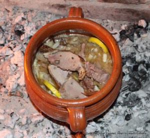 After the gravy, marjoram, capers, onions, anchovies, oysters, nutmeg and sliced lemon has been added to the redware stewpot for the receipt (recipe) To Harsh a Roast of Mutton stirre this all well together with the meat, let it stew till it be tender.  The meat is thin slices of mutton half-roasted.