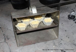 After all the ingredients have been mixed together and sweetened to the palate for the receipt (recipe) To make Pretty Little Cheesecurd Pudding butter your Patty pans and fill them with the Ingredients. The patty pans were placed on the shelf of a tin baker for baking with reflective heat from the fire.