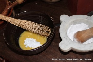 After the eggs have been beaten well for the receipt (recipe) Skirret Fritters sweeten it with powder sugar.  The marble mortar and wood pestle was used to prepare the sugar into powder.