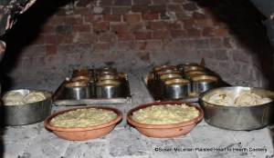 After the apples filled with marmalade were wrapped and arranged in baking tins for the receipt (recipe) Snow-balls bake them.  The Snow-balls are baking in the bake oven with Nun's Cakes in the back and Quince Pudding in the front.