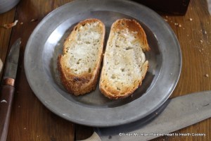 After the slices of the penny loaf have been toasted for the receipt (recipe) To make Spinach Toasts well butter the toasts and place them on the serving dish.