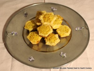 The 1681 receipt (recipe) Orange Cheese-cakes with a Past for Them is pictured served on a reproduction 17th century pewter plate garnished with candied violets.